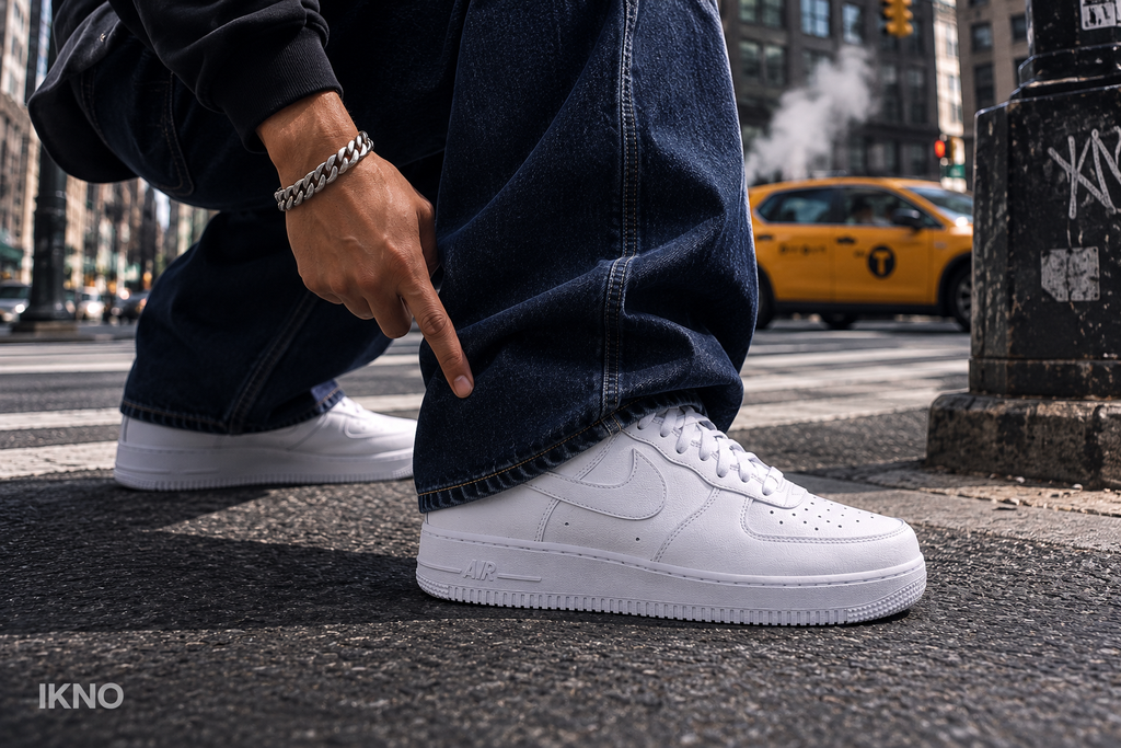 Person pointing at white Nike Air Force 1s in New York City